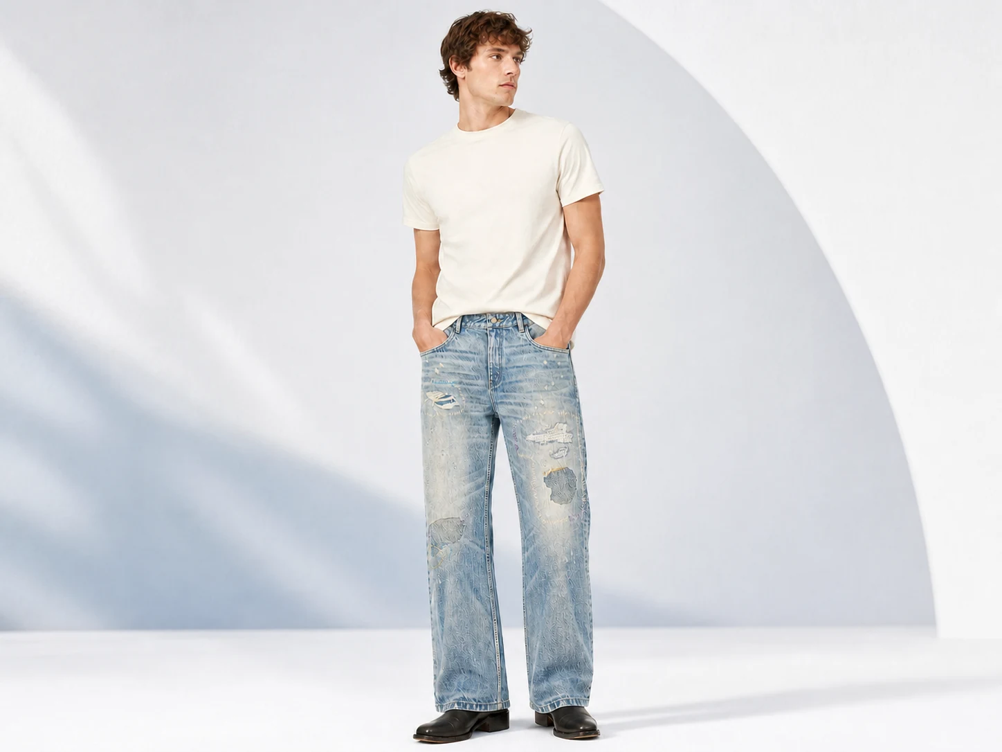 Male model wearing light-wash distressed wide-leg custom denim jeans