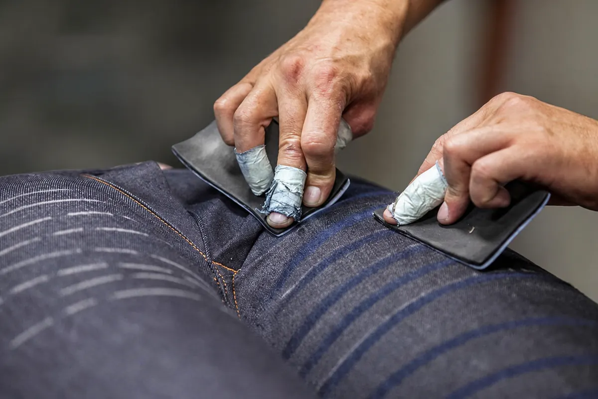 Manual whisker and finishing development on a denim garment sample