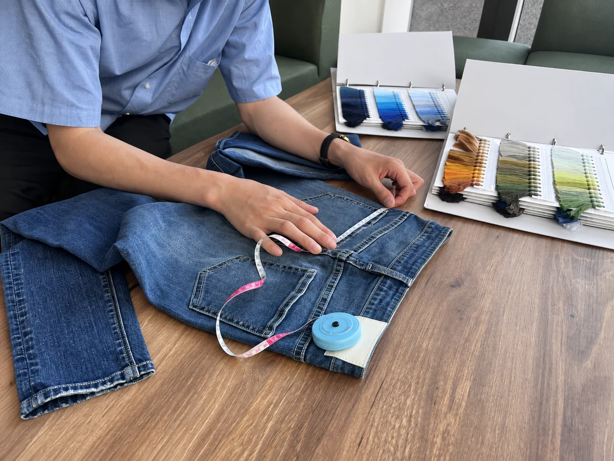 Denim specialist measuring a physical jeans sample during product development