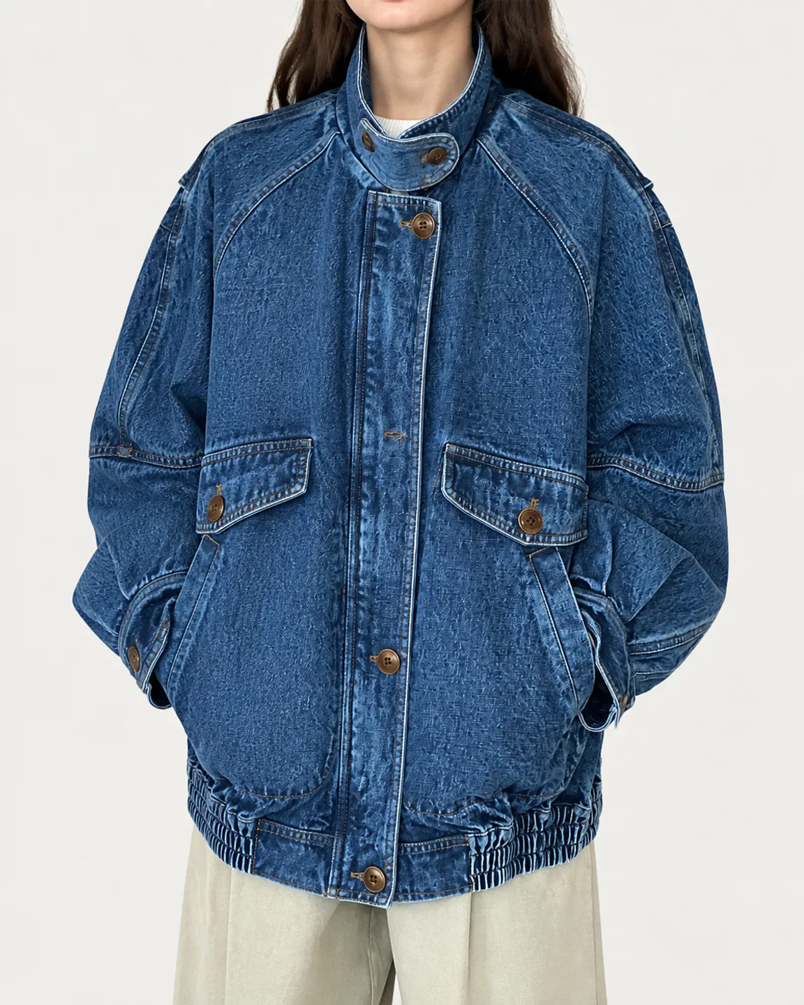 Women’s oversized medium-blue utility denim jacket with flap pockets and an elastic hem