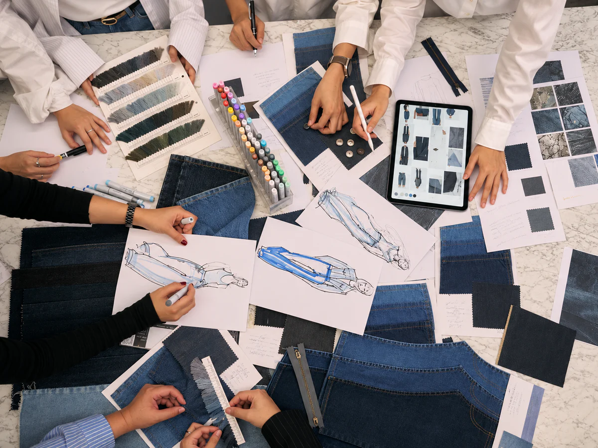 Denim design team reviewing reference images, sketches and fabric swatches