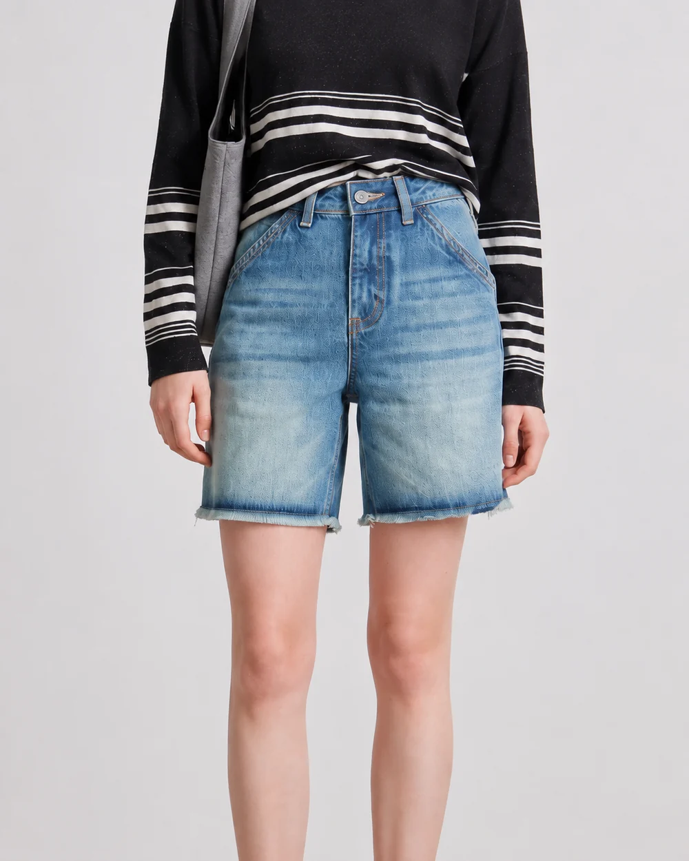 Women's light-wash Bermuda denim shorts with a high waist and raw hem