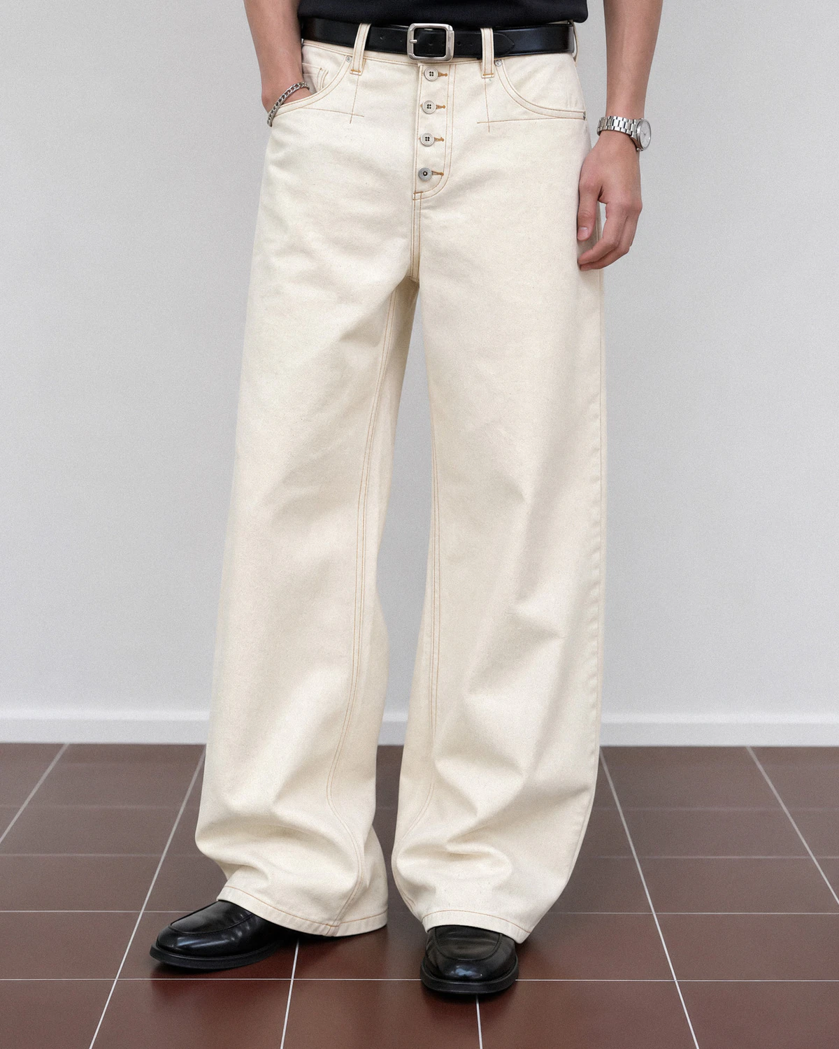 Ecru wide-leg denim jeans with contrast stitching and button-fly detail
