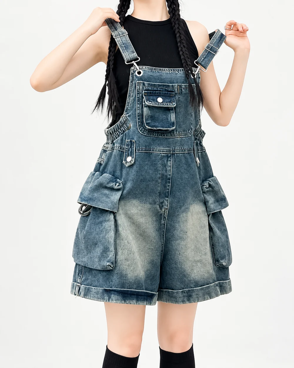 Faceless model wearing washed denim short overalls with oversized cargo utility pockets