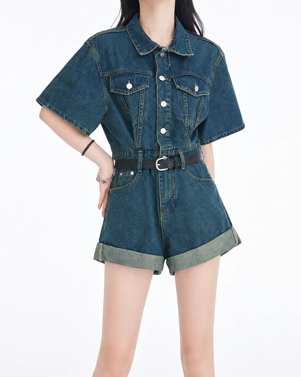 Faceless model wearing a dark-wash belted denim romper with short sleeves and western pockets