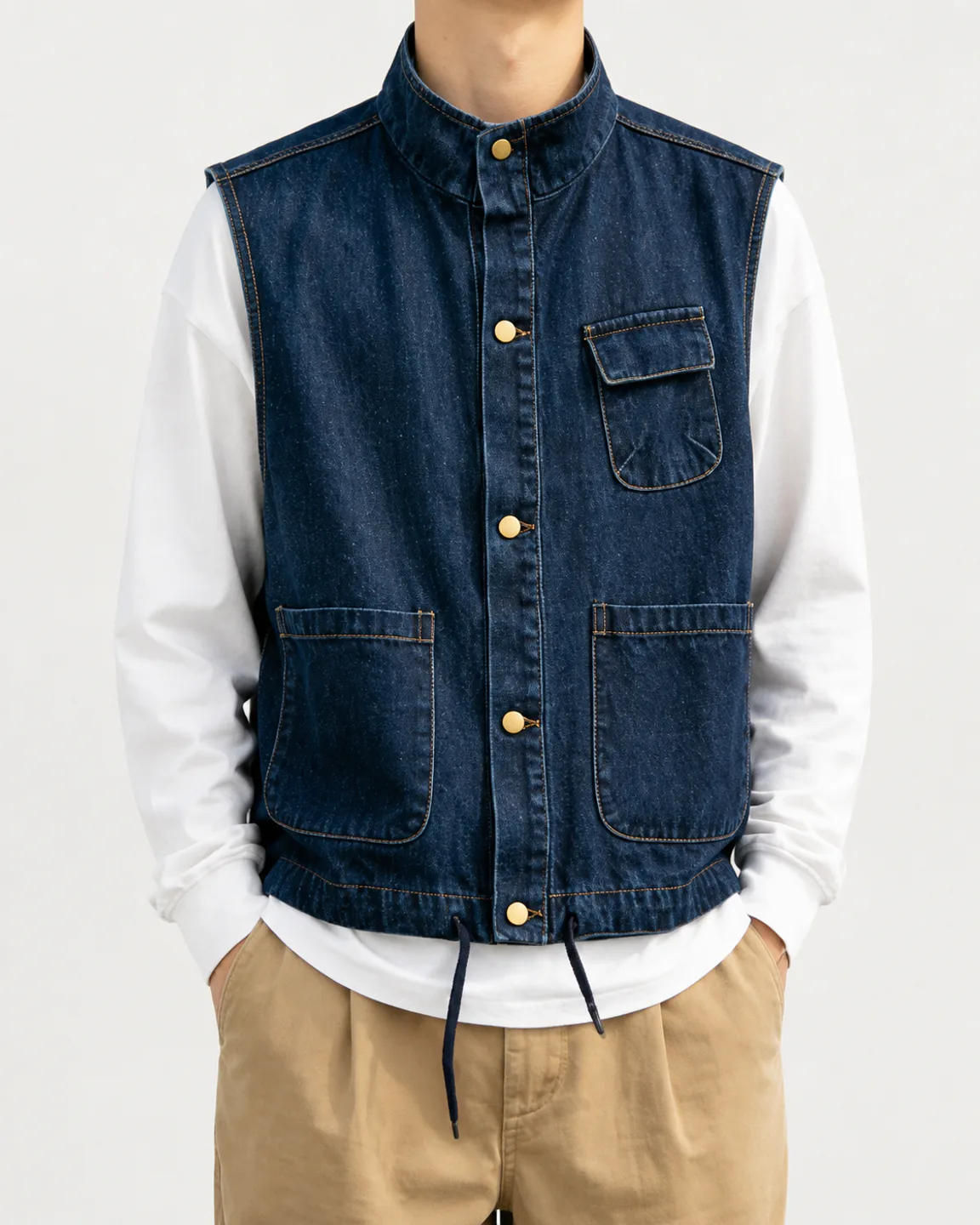 Men’s dark indigo utility denim vest with brass snaps and a drawcord hem
