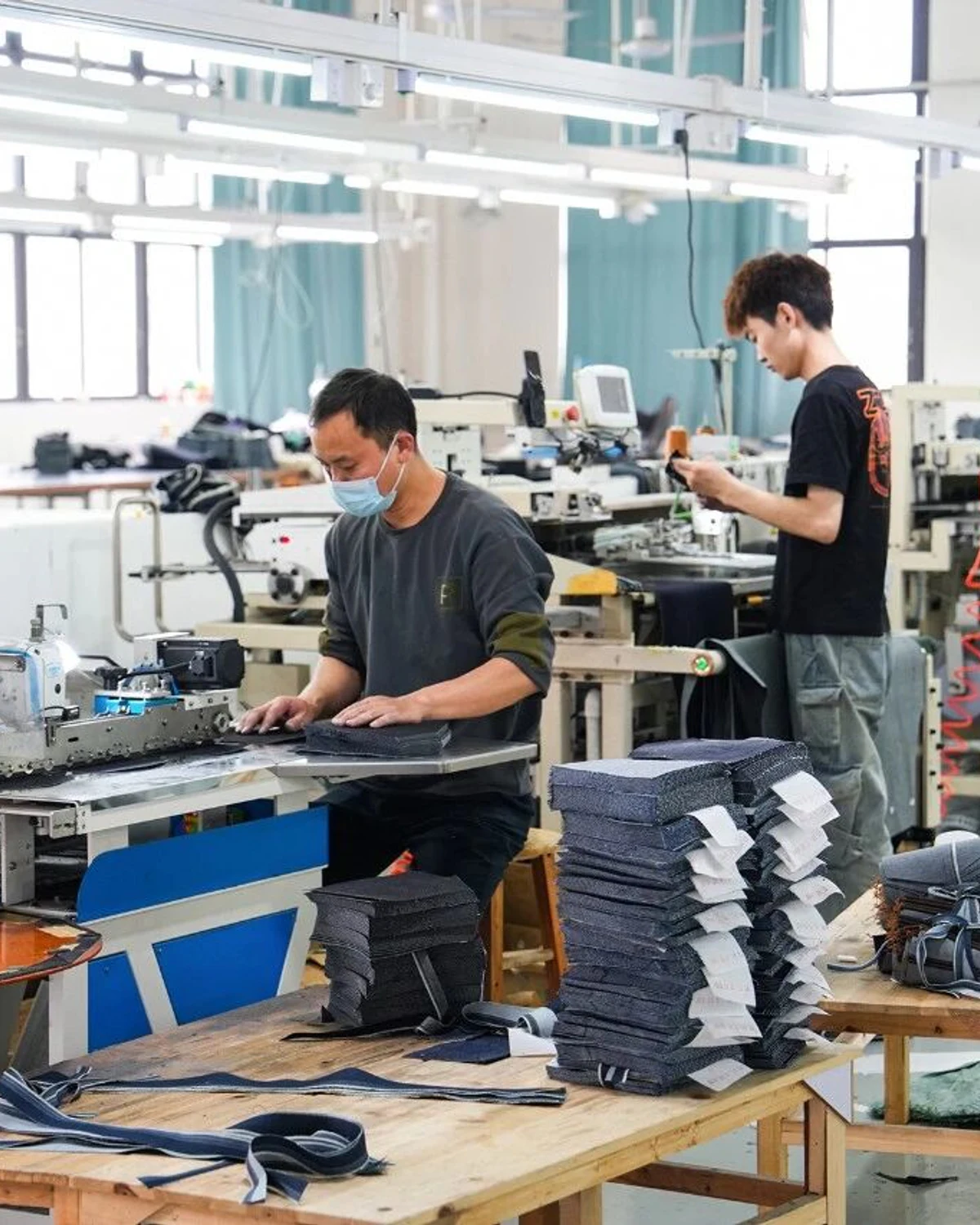Beilin Denim workers operating denim garment production equipment in Jun'an, Foshan