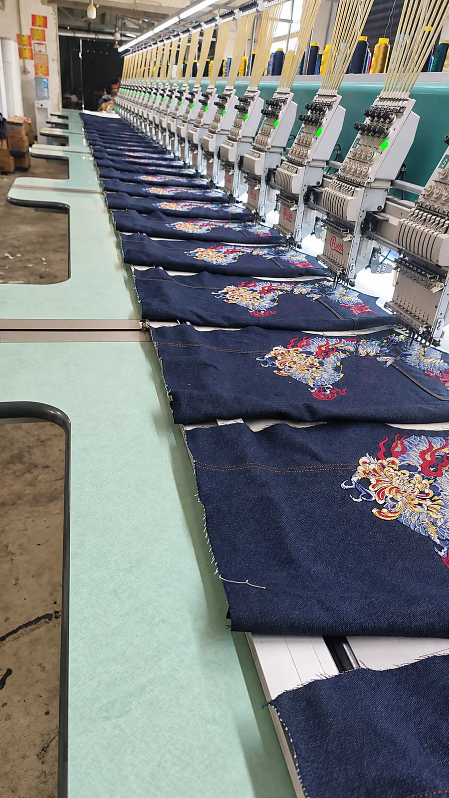 Computerized embroidery machines applying decorative motifs to denim panels