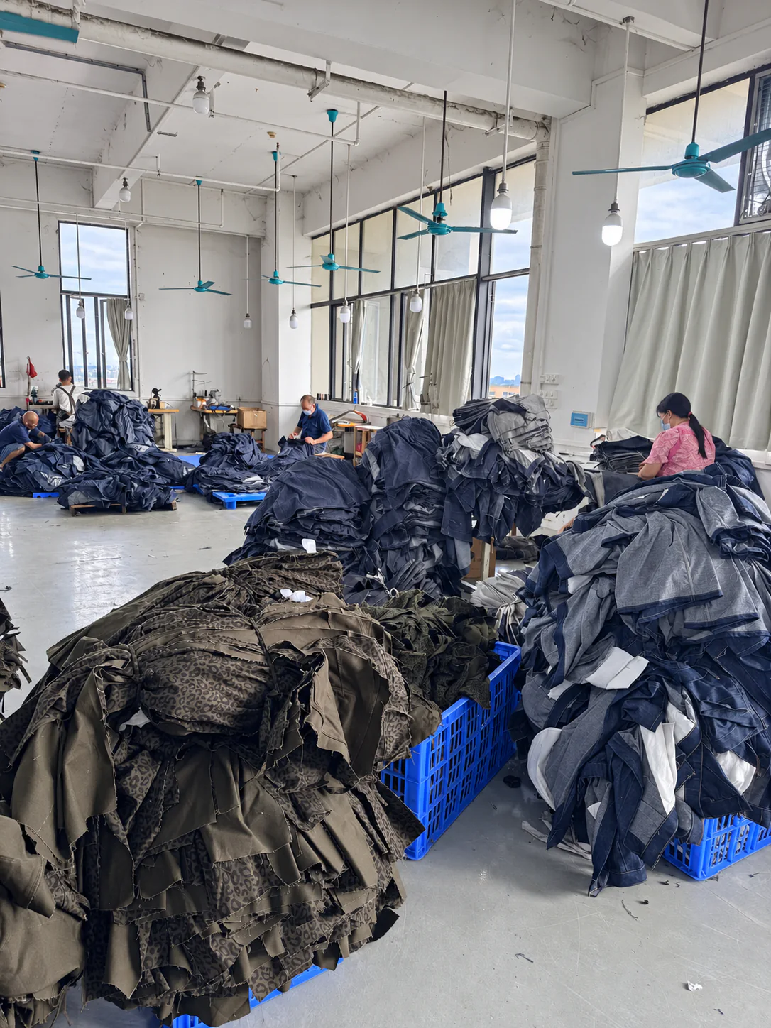Workers sorting denim garment components on the production floor