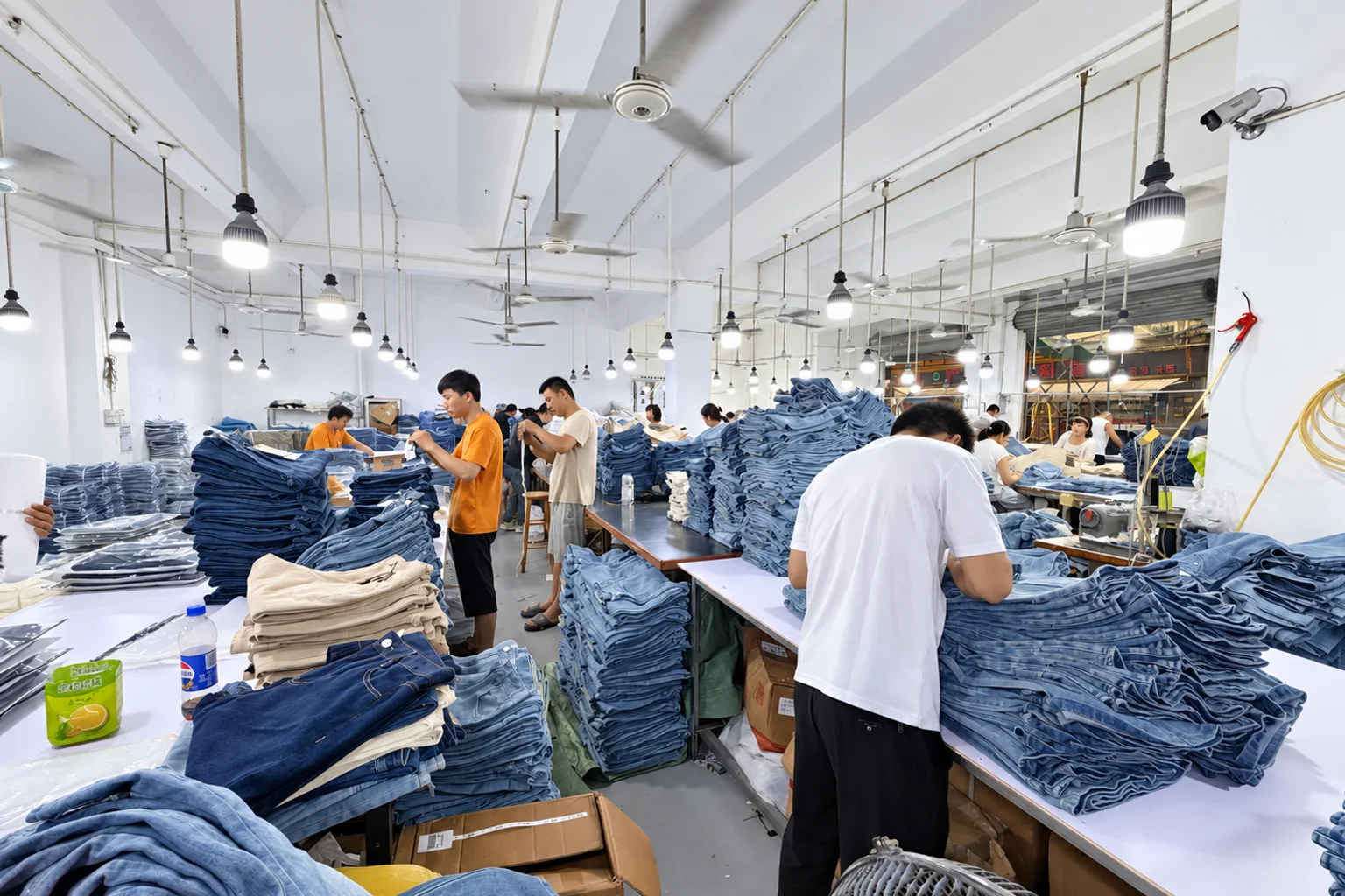 Workers inspecting finished denim jeans during bulk garment production at Beilin Denim