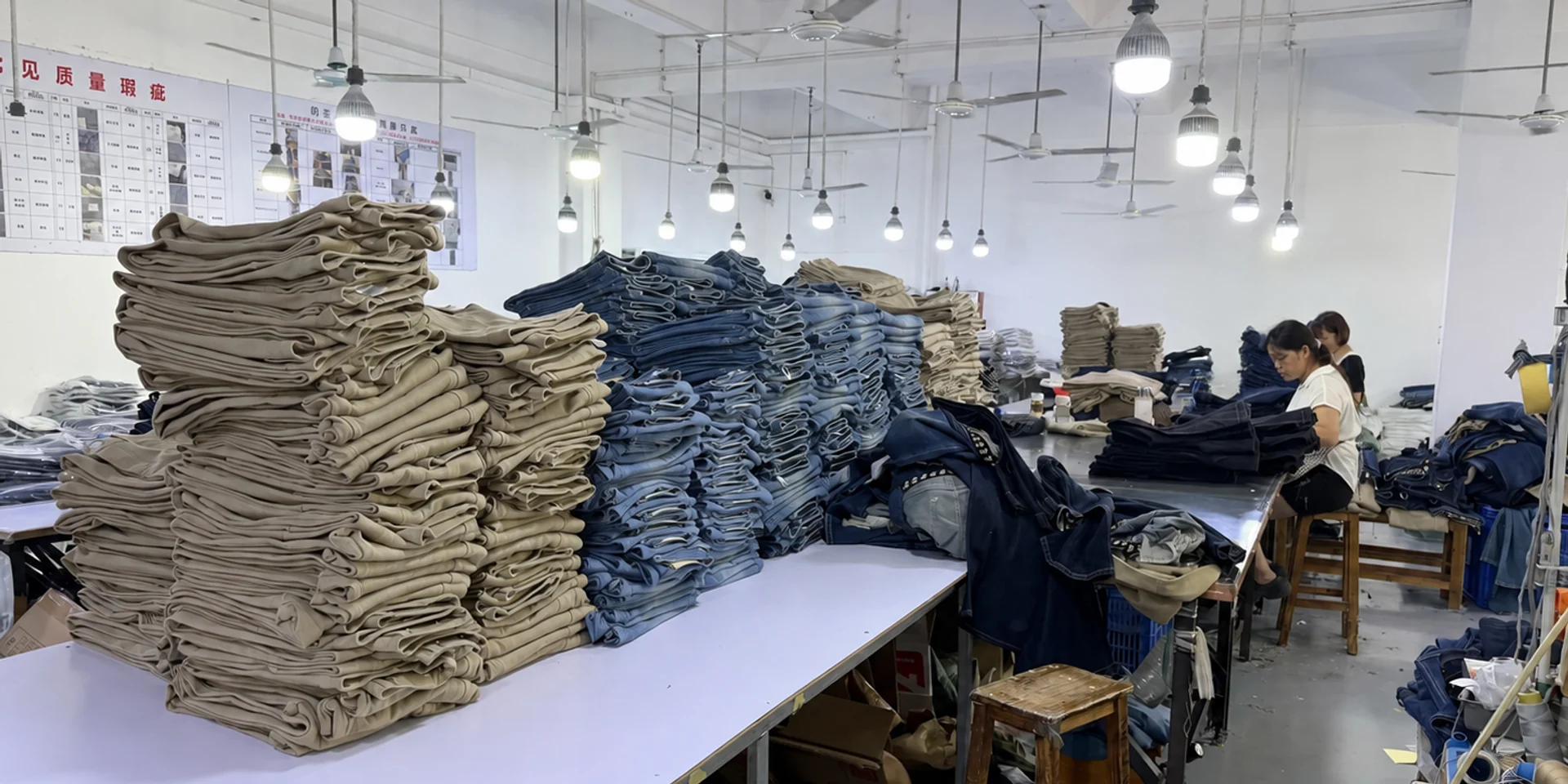 Bulk denim garments organized for sourcing and trading orders in a denim production facility