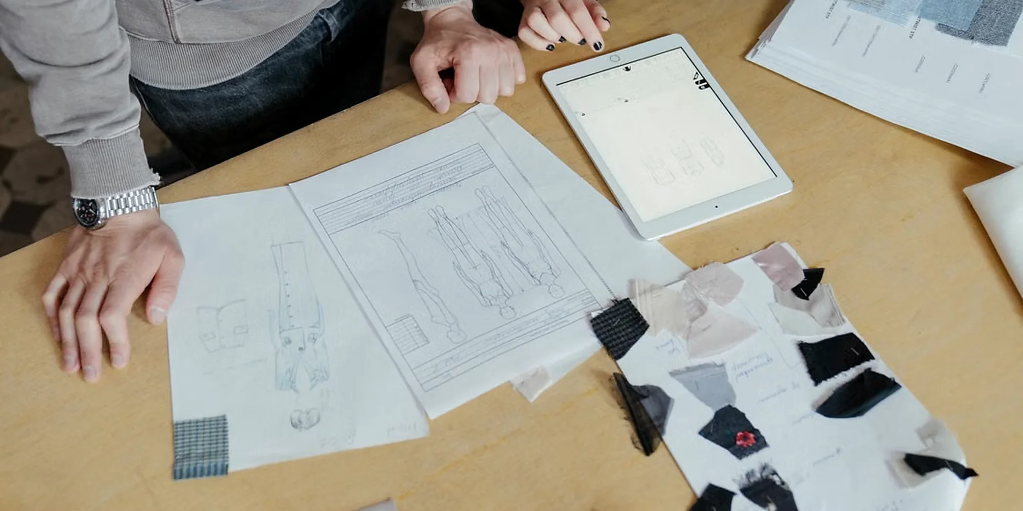 Fashion brand team reviewing garment specifications and fabric samples for custom denim development