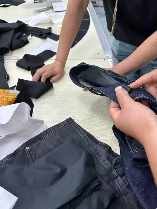 Worker inspecting the inside construction of a denim garment