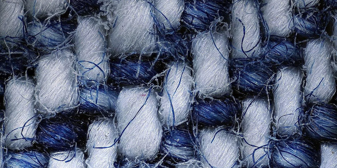 Extreme close-up of alternating blue and white yarns in a woven textile