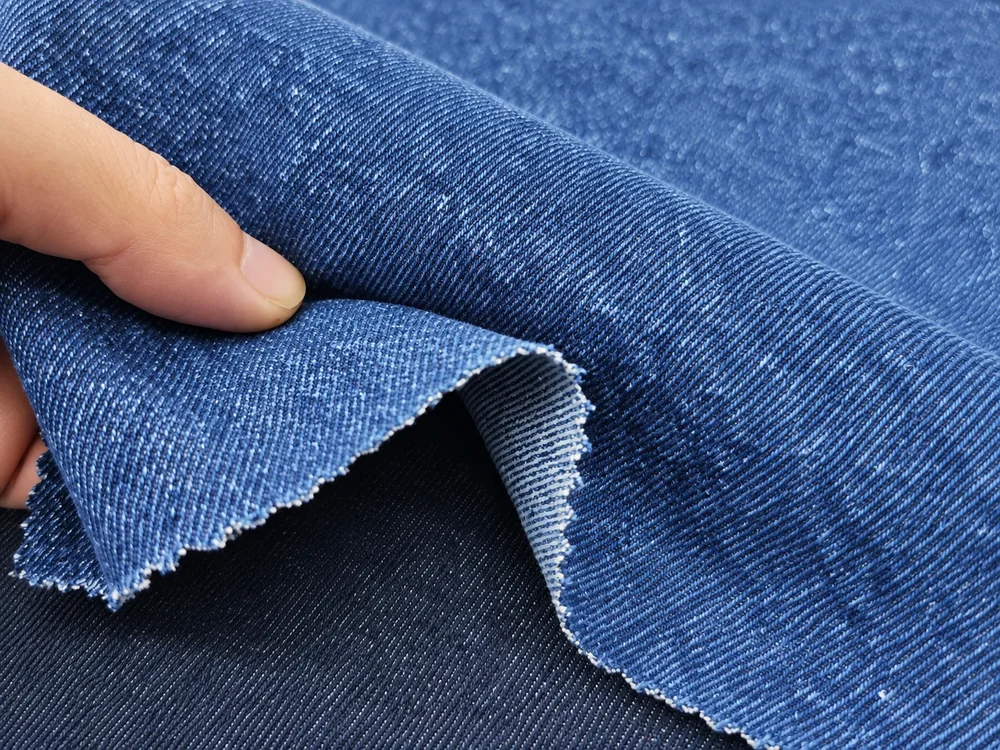 Hand checking the flexibility and hand feel of denim fabric